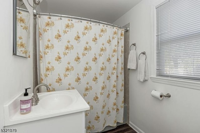 bathroom featuring shower / bath combo with shower curtain and vanity