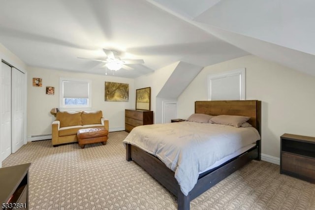 carpeted bedroom featuring a closet, lofted ceiling, baseboard heating, and ceiling fan