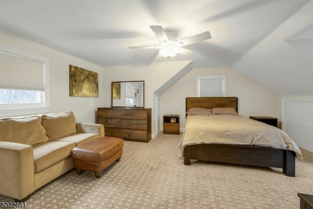 carpeted bedroom with ceiling fan and vaulted ceiling