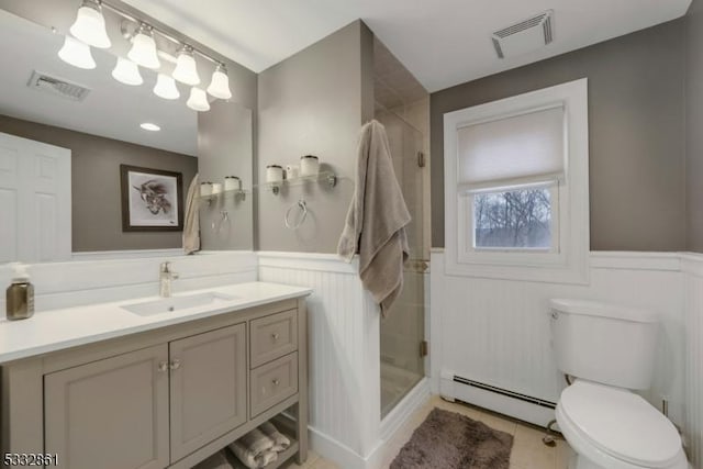 bathroom with tile patterned flooring, toilet, tiled shower, vanity, and a baseboard heating unit