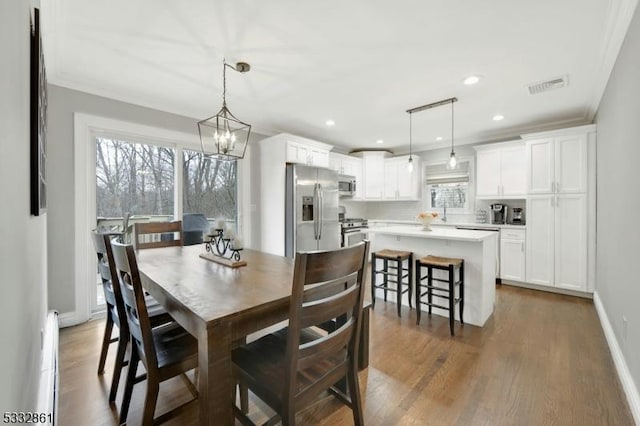 dining room featuring ornamental molding, dark hardwood / wood-style floors, and a chandelier