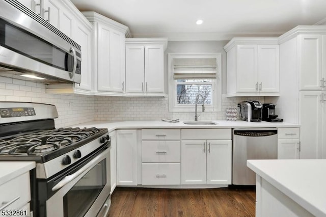 kitchen with stainless steel appliances, white cabinetry, sink, and tasteful backsplash