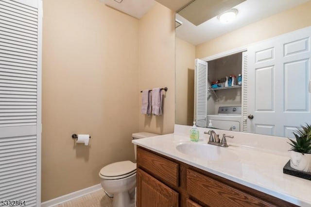 bathroom with toilet, washer / clothes dryer, and vanity