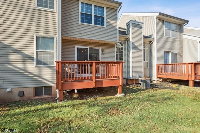 rear view of property featuring a wooden deck, cooling unit, and a yard