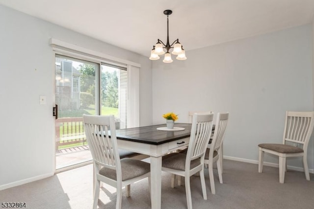 carpeted dining area featuring an inviting chandelier