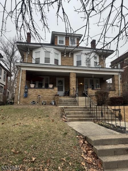 view of front of house with a front yard and covered porch