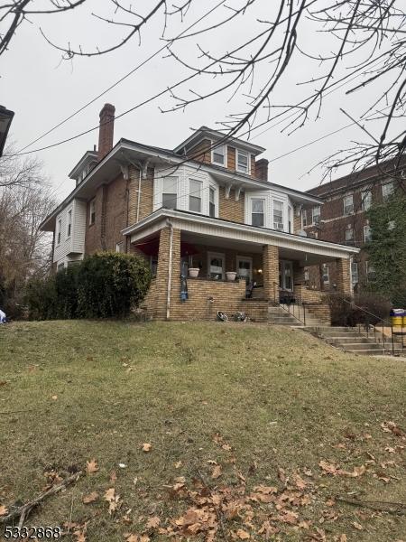 view of front of home featuring covered porch and a front lawn