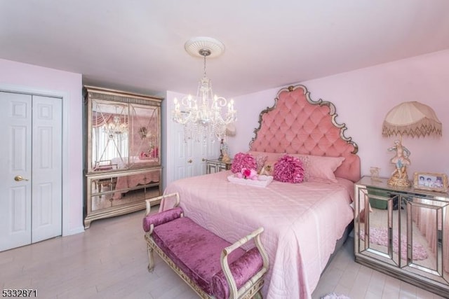 bedroom featuring a notable chandelier and light hardwood / wood-style flooring