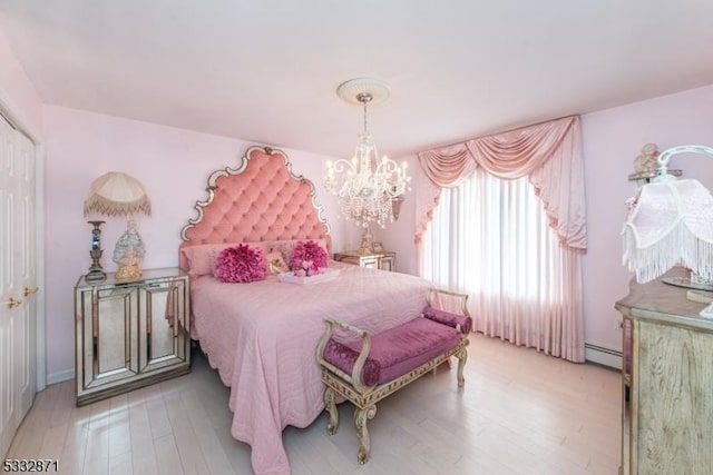 bedroom with baseboard heating, a notable chandelier, and light hardwood / wood-style flooring