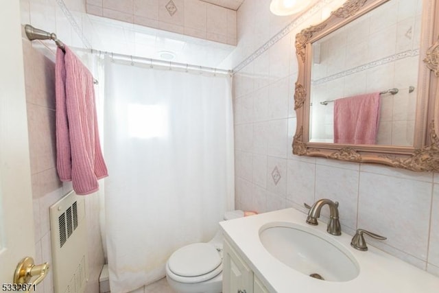 bathroom featuring toilet, tile walls, backsplash, radiator heating unit, and vanity