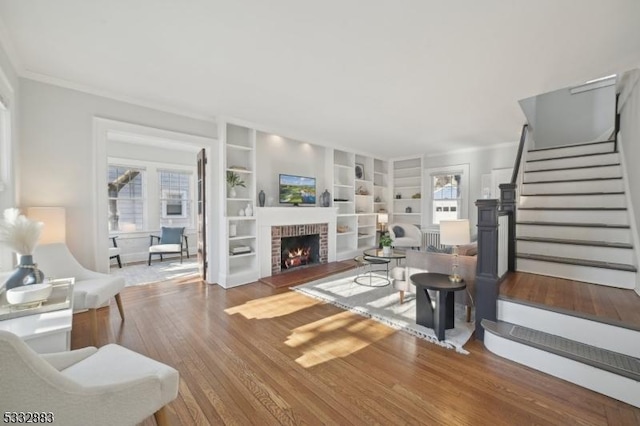 living room featuring hardwood / wood-style flooring, plenty of natural light, a fireplace, and built in shelves