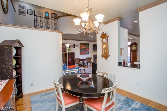 dining room with an inviting chandelier, ornamental molding, and wood-type flooring