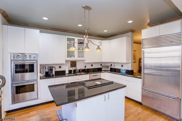 kitchen with stainless steel appliances, white cabinetry, pendant lighting, and a center island