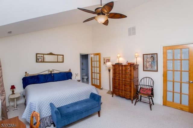 carpeted bedroom with ceiling fan and high vaulted ceiling