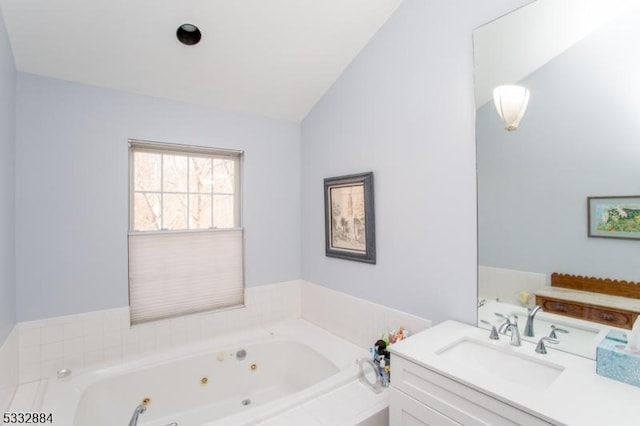 bathroom featuring lofted ceiling, a relaxing tiled tub, and vanity