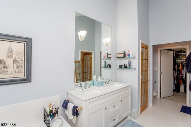 bathroom featuring tile patterned flooring, a towering ceiling, and vanity