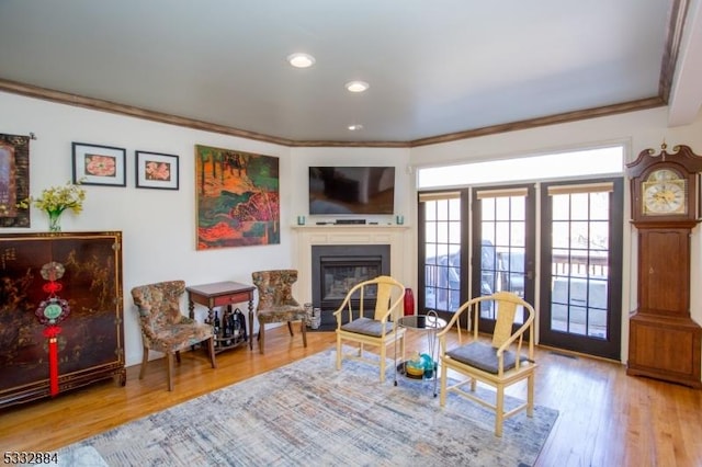 sitting room featuring ornamental molding and wood-type flooring