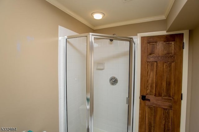 bathroom featuring ornamental molding and an enclosed shower