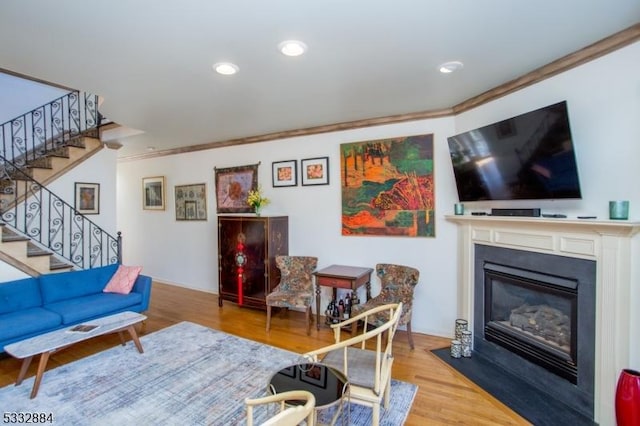 living room featuring crown molding and light hardwood / wood-style flooring