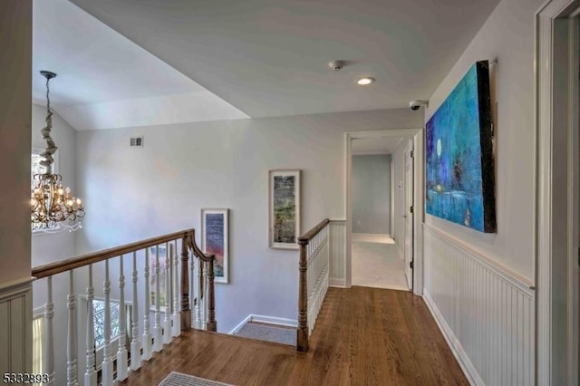 hall featuring dark hardwood / wood-style flooring and a chandelier