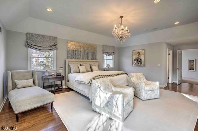 bedroom featuring hardwood / wood-style flooring, a raised ceiling, and a chandelier