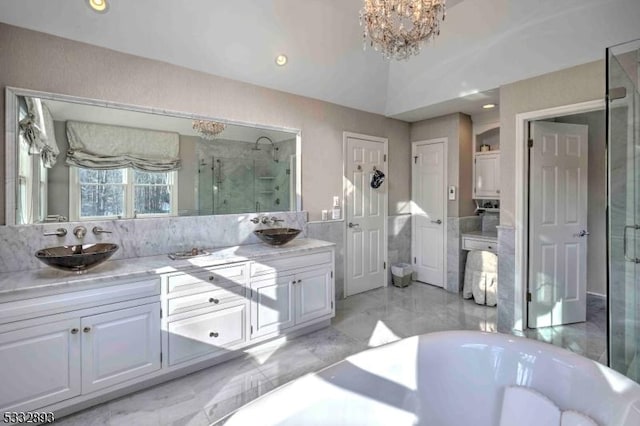 bathroom with an enclosed shower, vanity, and a notable chandelier