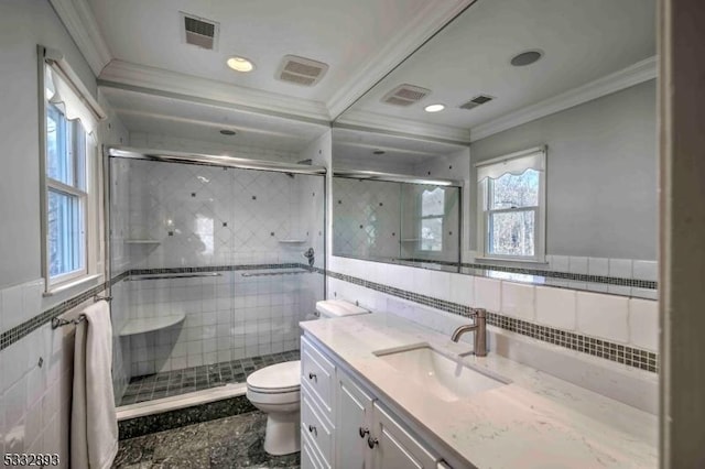 bathroom with toilet, ornamental molding, tile walls, and a shower with shower door