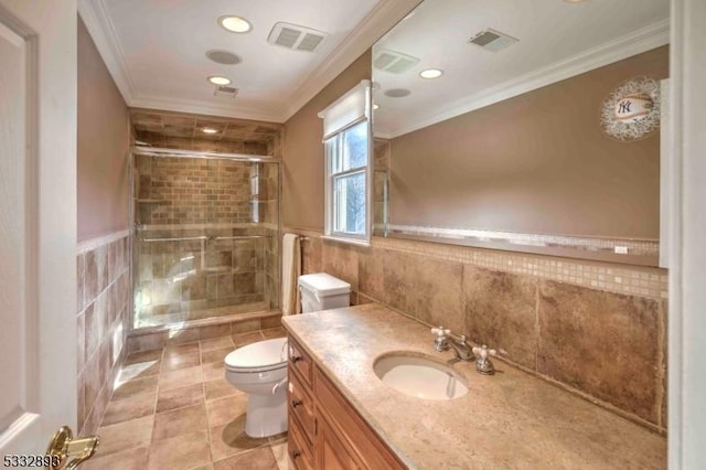 bathroom featuring vanity, tile walls, toilet, ornamental molding, and a shower with shower door