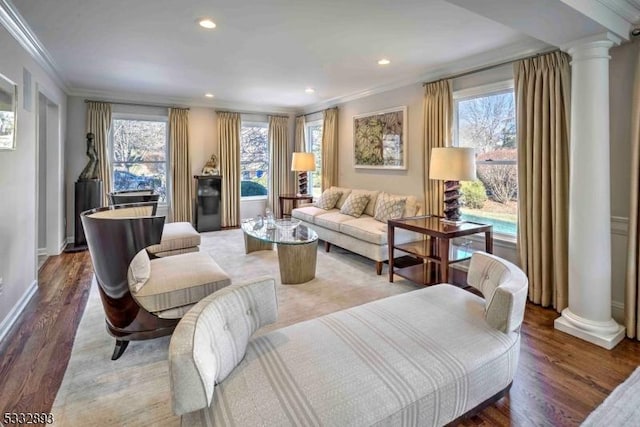 living room featuring ornate columns, ornamental molding, and hardwood / wood-style floors