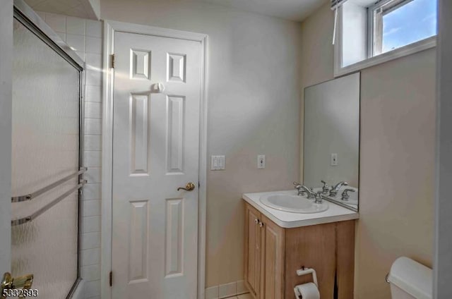 bathroom with toilet, vanity, and an enclosed shower