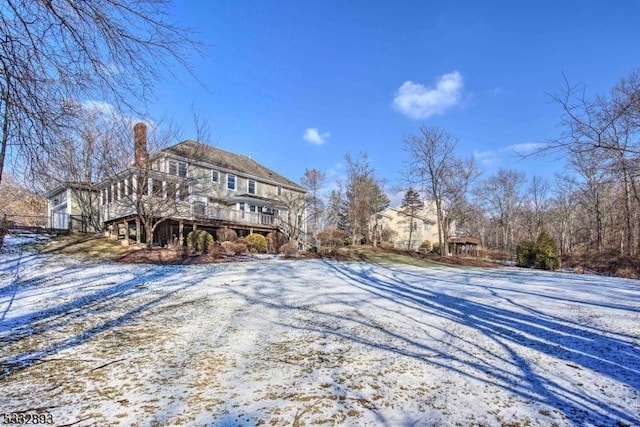 view of snow covered rear of property