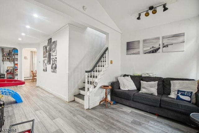 living room with light wood-type flooring, a baseboard radiator, lofted ceiling, and rail lighting