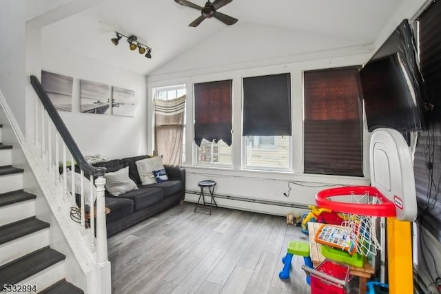 interior space with lofted ceiling, a baseboard heating unit, and ceiling fan