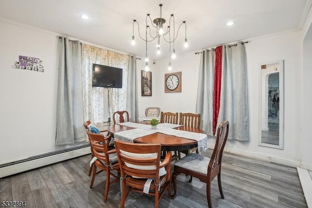 dining area with a baseboard radiator, a chandelier, hardwood / wood-style floors, and ornamental molding