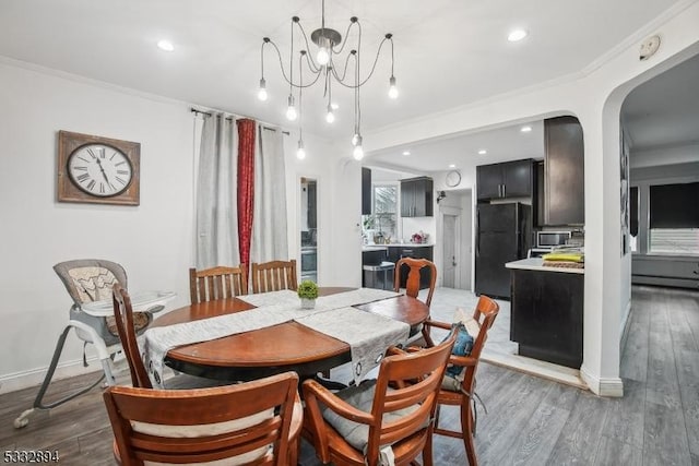 dining room with dark hardwood / wood-style flooring, an inviting chandelier, and crown molding