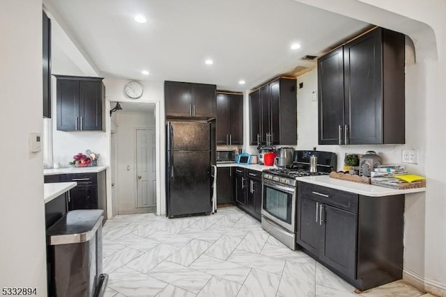 kitchen with black fridge and stainless steel gas stove