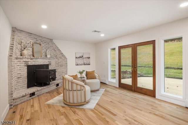 living area featuring a wood stove, hardwood / wood-style floors, and french doors