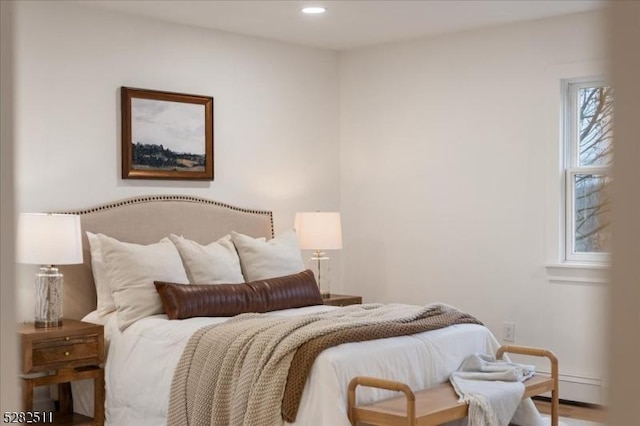 bedroom with a baseboard heating unit and multiple windows