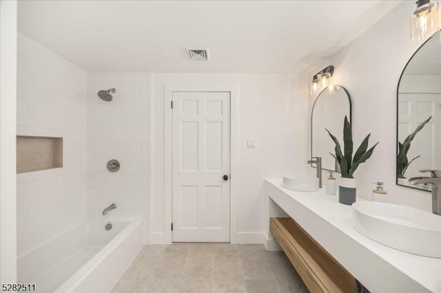 bathroom featuring tiled shower / bath combo, tile patterned floors, and vanity