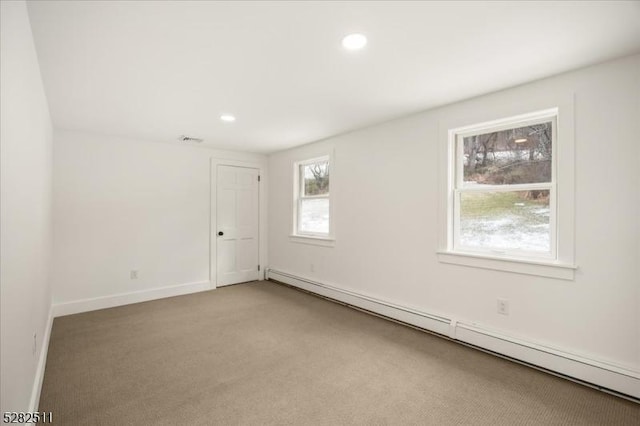 spare room featuring light carpet and a baseboard radiator