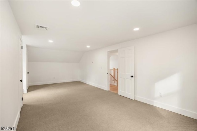 bonus room with light carpet and lofted ceiling