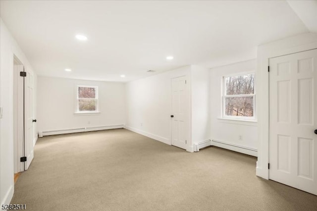 carpeted empty room featuring baseboard heating