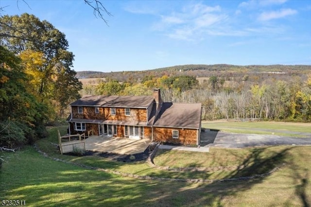 back of property with a yard and a patio