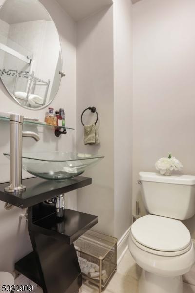 bathroom featuring toilet, tile patterned flooring, and sink