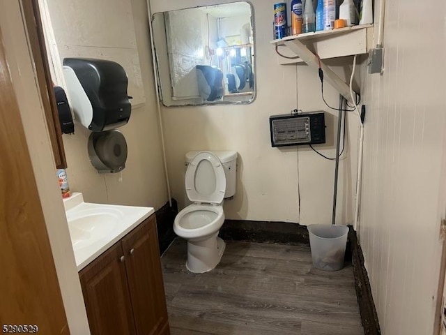 bathroom with toilet, wood-type flooring, and vanity