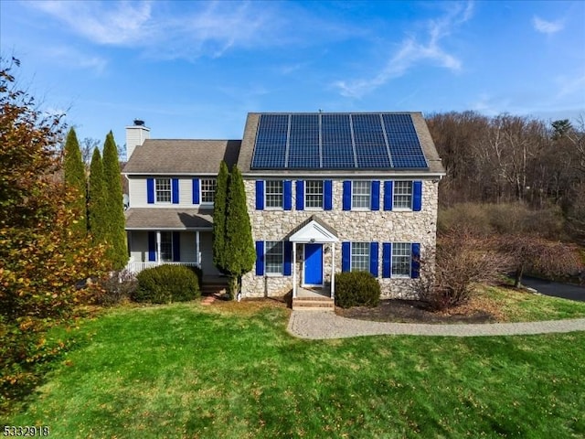 colonial house with solar panels and a front yard