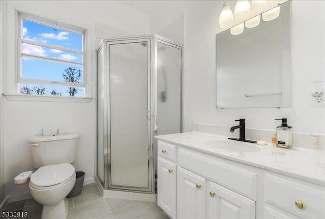 bathroom featuring tile patterned floors, toilet, a shower with door, and vanity