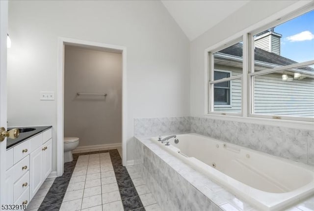 bathroom featuring tile patterned flooring, toilet, vaulted ceiling, vanity, and a relaxing tiled tub