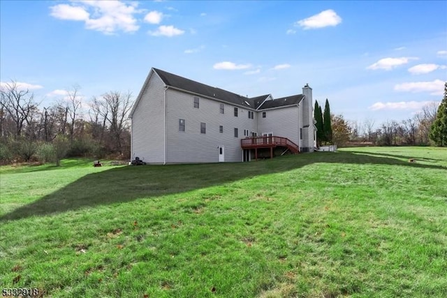 rear view of house with a lawn and a deck