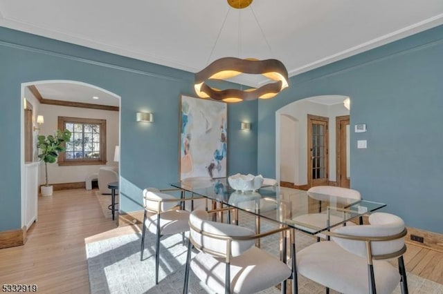 dining room with ornamental molding and light wood-type flooring